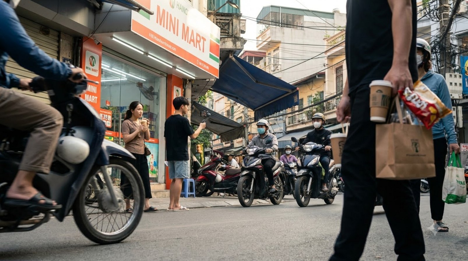Người quay phim trước cửa hàng, xe máy và khách mua hàng ngoài phố